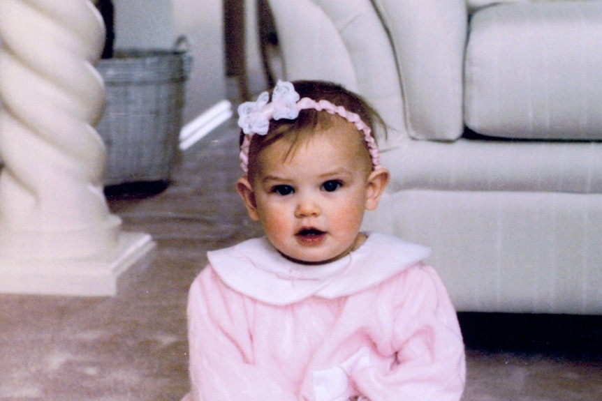 Lala Kent as a little baby wearing a pink onsie and a head bow.