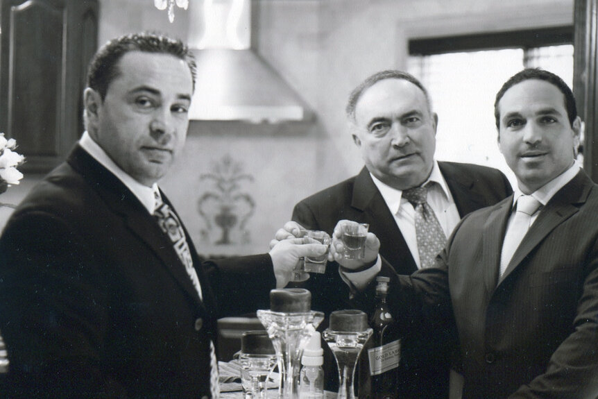 Joe Gorga posing in a suit with Joe Giudice and another friend.